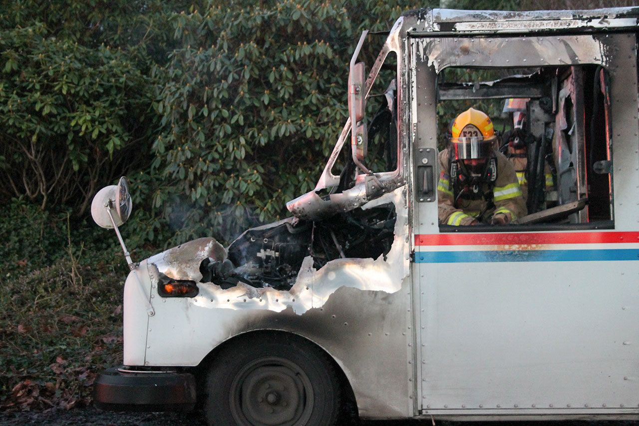 Kyle Jensen / The Record                                Firefighters examine the extent of the damage to the mail truck.