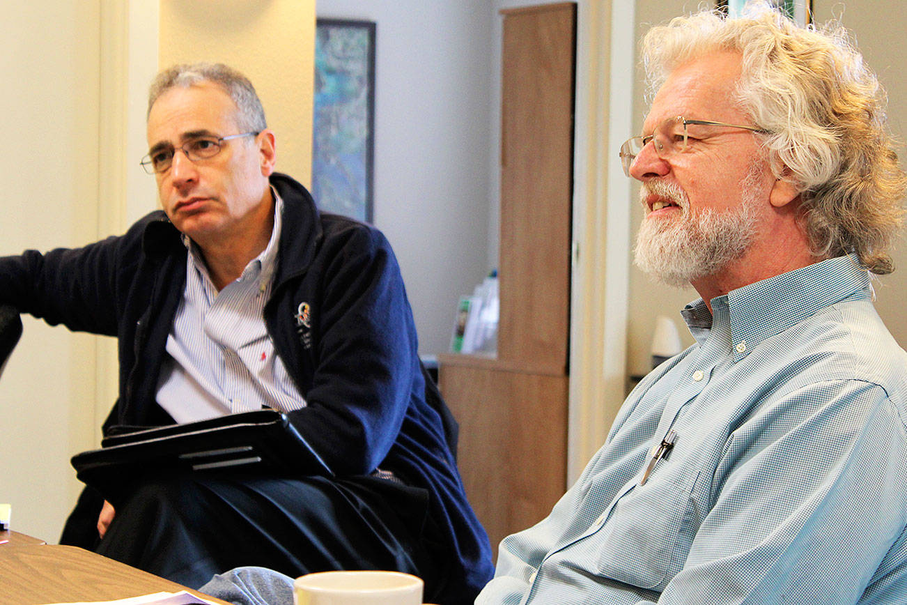 Michael Shuman, left, author of a report on the “hidden costs” of Naval Air Station Whidbey Island, visits Island County Economic Development Office in Coupeville on Tuesday. Larry Morrell, right, is with the citizen group, Sustainable Economy Collaborative, that hired Shuman for the economic impact investigation.