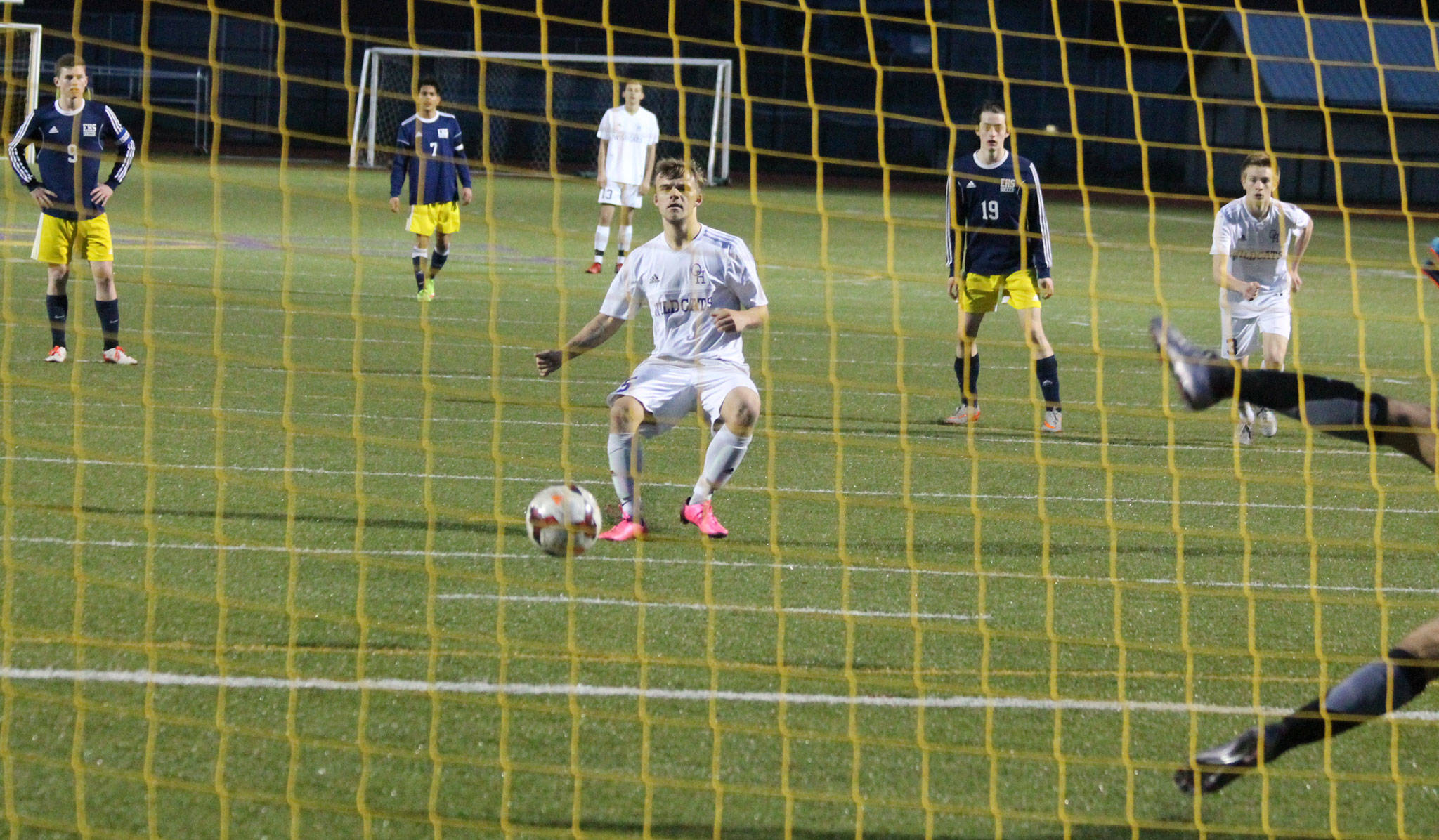 Spencer Champion (pink shoes) watches as his penalty kick heads toward the net for a goal. Everett goalkeeper Jose Neri-Guzman (feet showing on the far right) guessed wrong and dove the opposite direction of Champion’s shot. (Photo by Jim Waller/Whidbey News-Times)