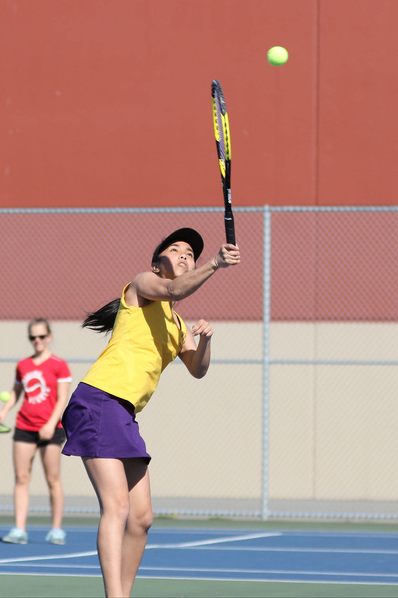 Aelizah Espiritu hits an overhead shot in her win in first singles. (Photo by John Fisken)