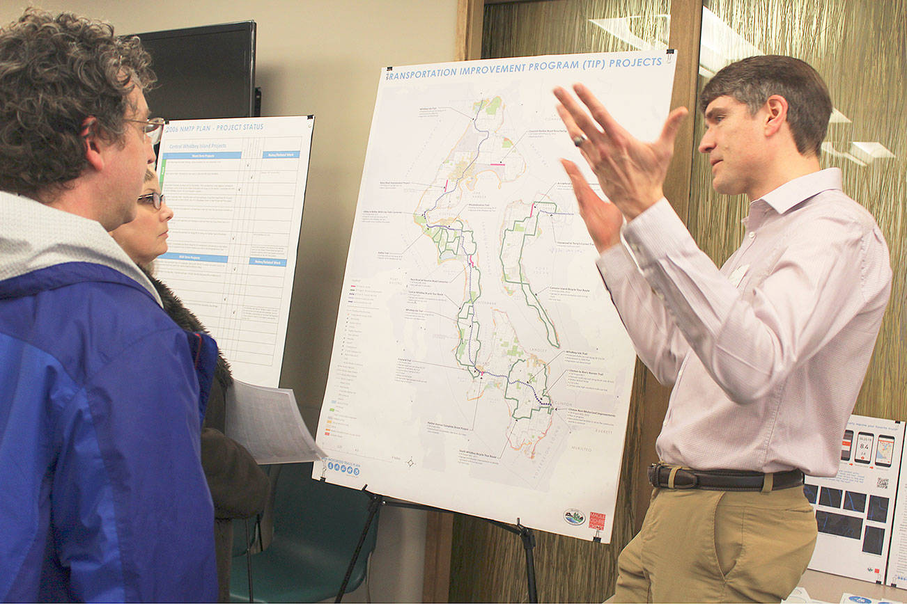 Residents look over maps for possible additions to hiking, biking and beach areas on Whidbey Island during public meetings this winter. A second round of meetings take place in June on the non-motorized trail plan. County planner Brian Wood explains the bike trail system at a Coupeville meeting earlier this year.