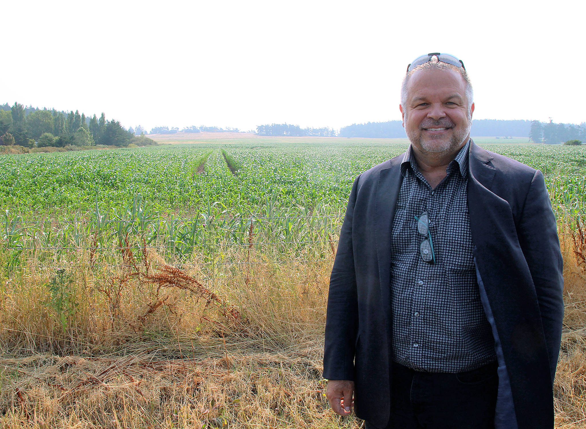 Photo by Jessie Stensland / Whidbey News-Times                                Oak Harbor resident Scott Thompson stands in front of a cornfield that his development group has proposed turning into a large affordable-housing project.