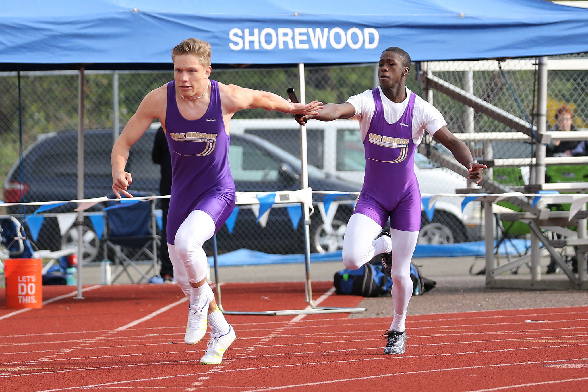 Oak Harbor’s Andrew Miller takes the first handoff from Jeff Gordon in the Wildcats’ win in the 4x100 relay at the district meet Friday. (Photo by John Fisken)