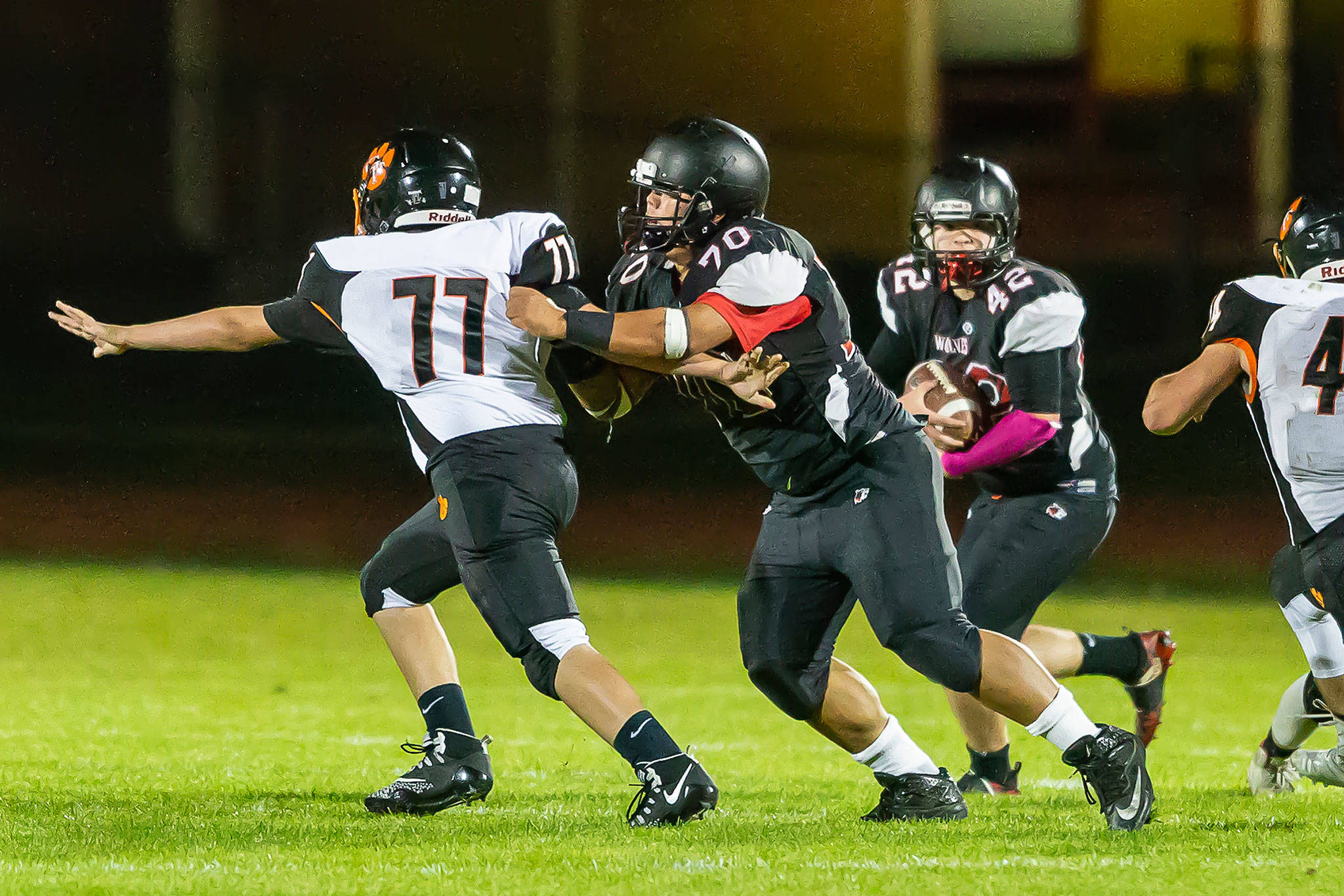 Andrew Martin (42) looks for some running room as Ryan Labrador (70) blocks the Tigers’ Samuel Morrison.(Photo by John Fisken)