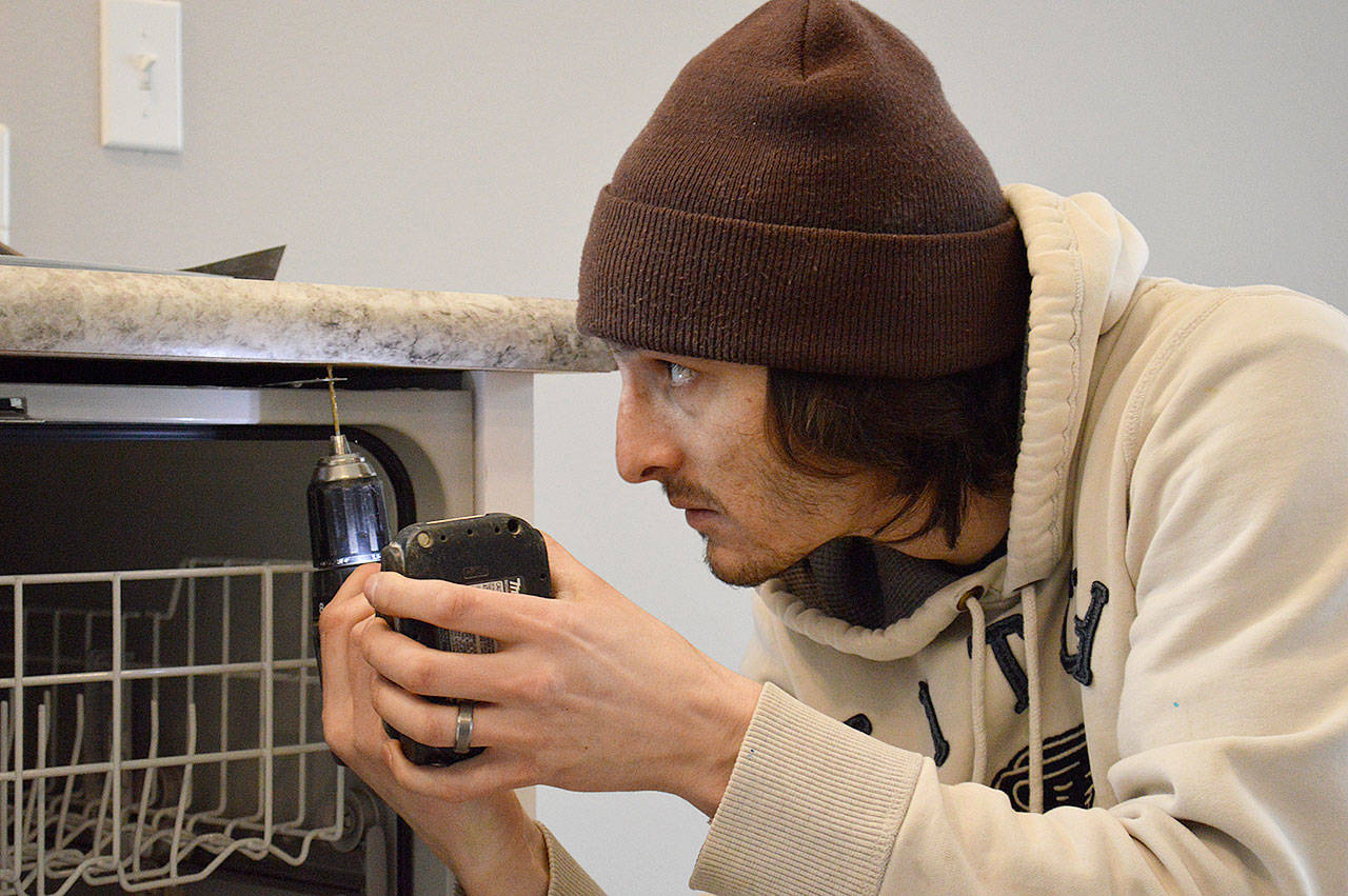 Ian Miranda installs a dishwasher in a newly built home in Coupeville. The town council voted to significantly lower fees, which were much higher than in nearby jurisdictions. (Photo by Laura Guido/Whidbey News-Times)