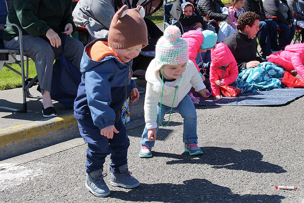 Amelia MacLean and twin brother Wallace make a mad dash to scoop up candy tossed out at the Holland Happening parade.                                (Photos by Maria Matson/Whidbey News-Times)