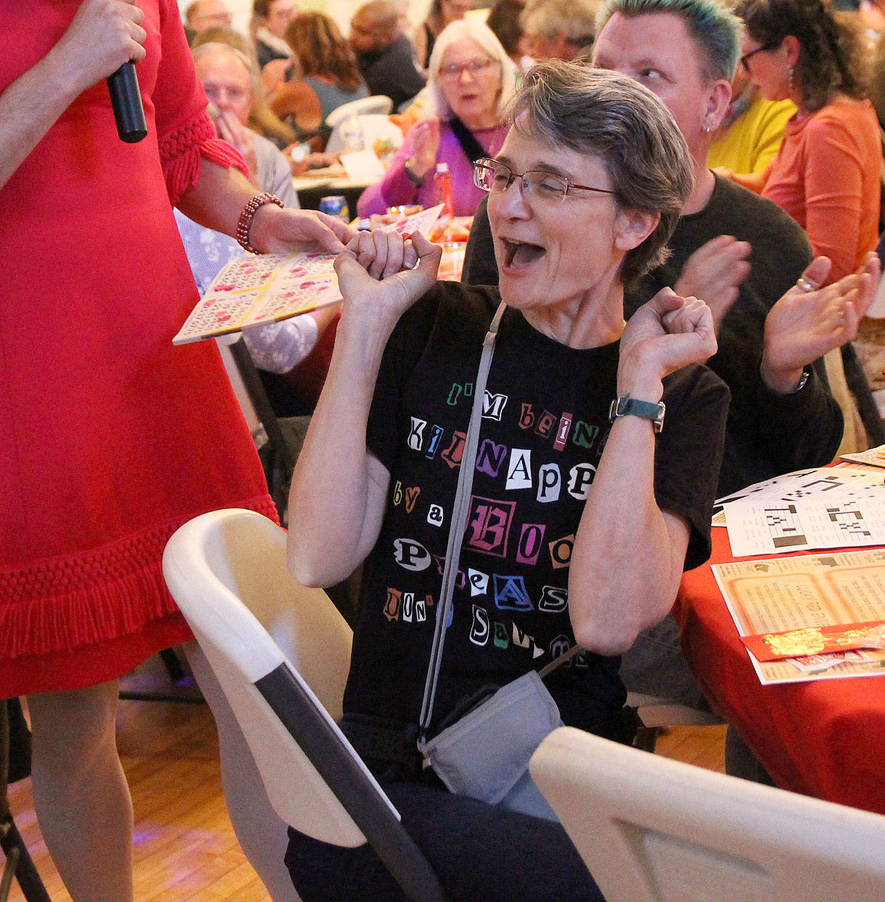 Shannon O’Phelan celebrates after winning a round at Not Your Grandma’s Bingo Saturday night at Bayview Hall. One of the hosts Bobbi Jo Blessings, who also goes by Kerry Nielsen, verifies her card. Proceeds from the event go toward Island Senior Resources.