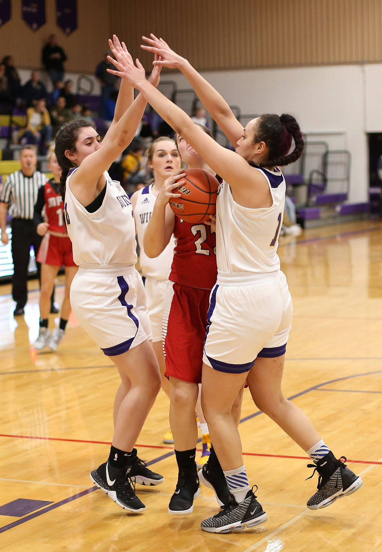 Oak Harbor’s Anna Jones, left, and Jasmine Ford double team Marysville-Pilchuck’s Alissa Edge.(Photo by John Fisken)