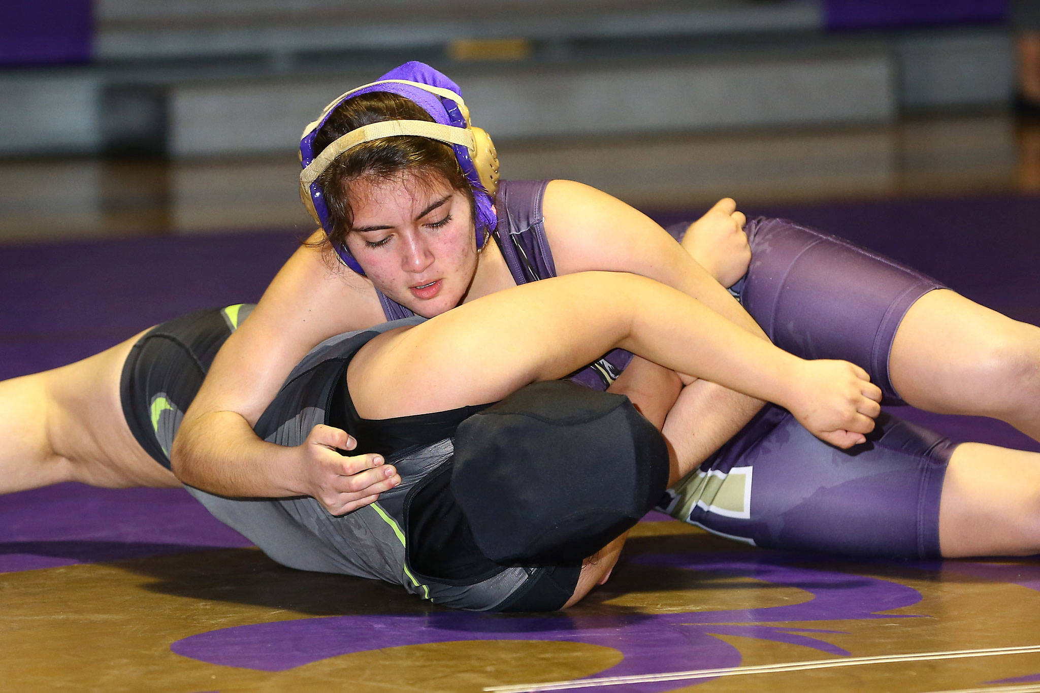 Oak Harbor’s Abigail Correa Cruz, top, pins her Lynden opponent Wednesday.(Photo by John Fisken)