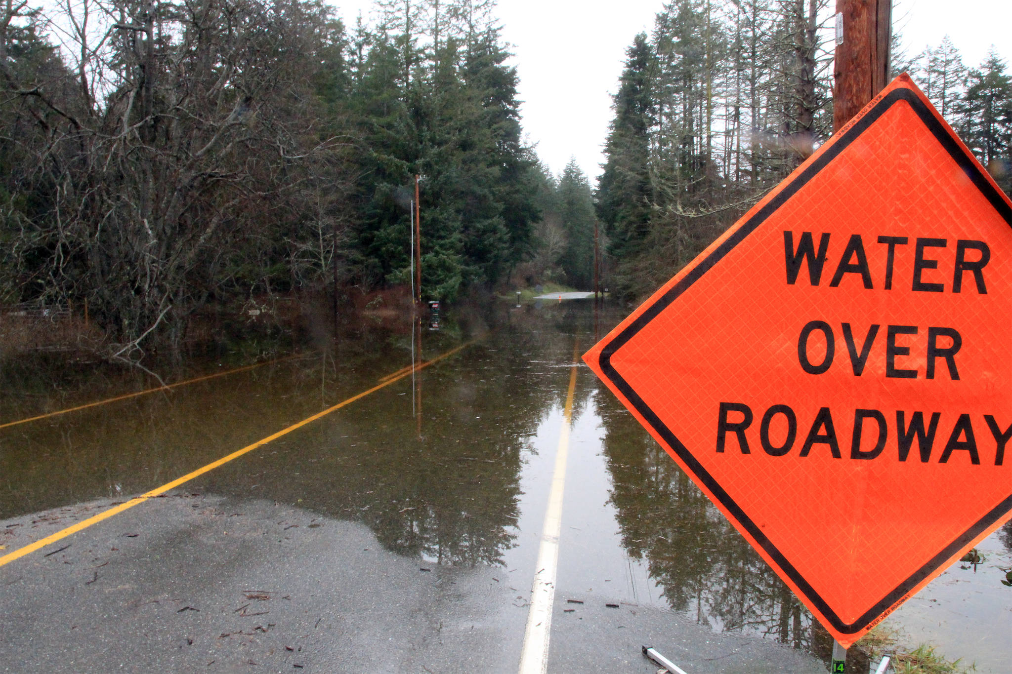 Photo by Brandon Taylor / Whidbey News-Times                                Cougar Road on North Whidbey was closed because of flooding Friday. Firefighters used a boat to evacuate residents.