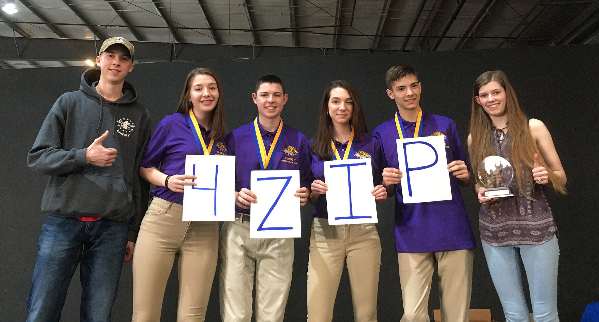 Shooters Trevor Westman, left, Lauren Crossley, James Hart, Alexis Kunze and Cheyenne Maggard give a shootout to coach Dave “Zip” Goodman, who could not attend the NJROTC championships with them. (Photo provided.)