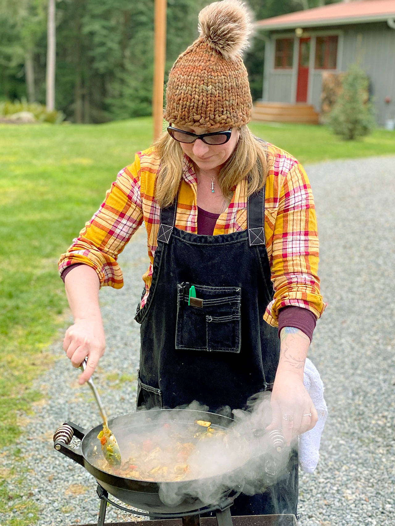 Photo provided                                Jess Dowdell, owner of Roaming Radish catering, grills over a fire.