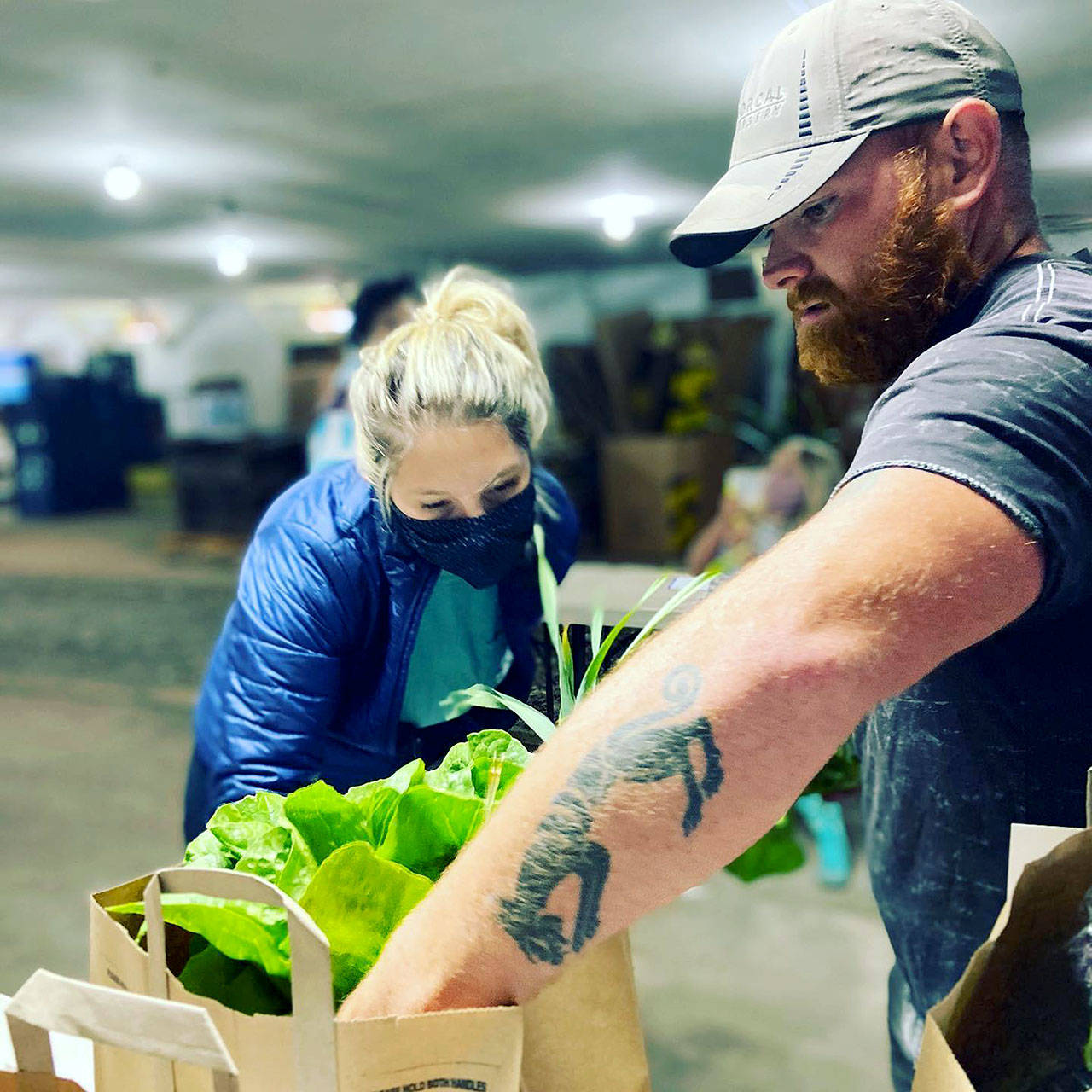 Photos provided                                Lauren Fletcher of Mutiny Bay Blues and Kyle Flack of Bell’s Farm pack weekly Food Hub orders. Flack said COVID-19 has helped people realize the importance of small-scale farming and shopping locally.