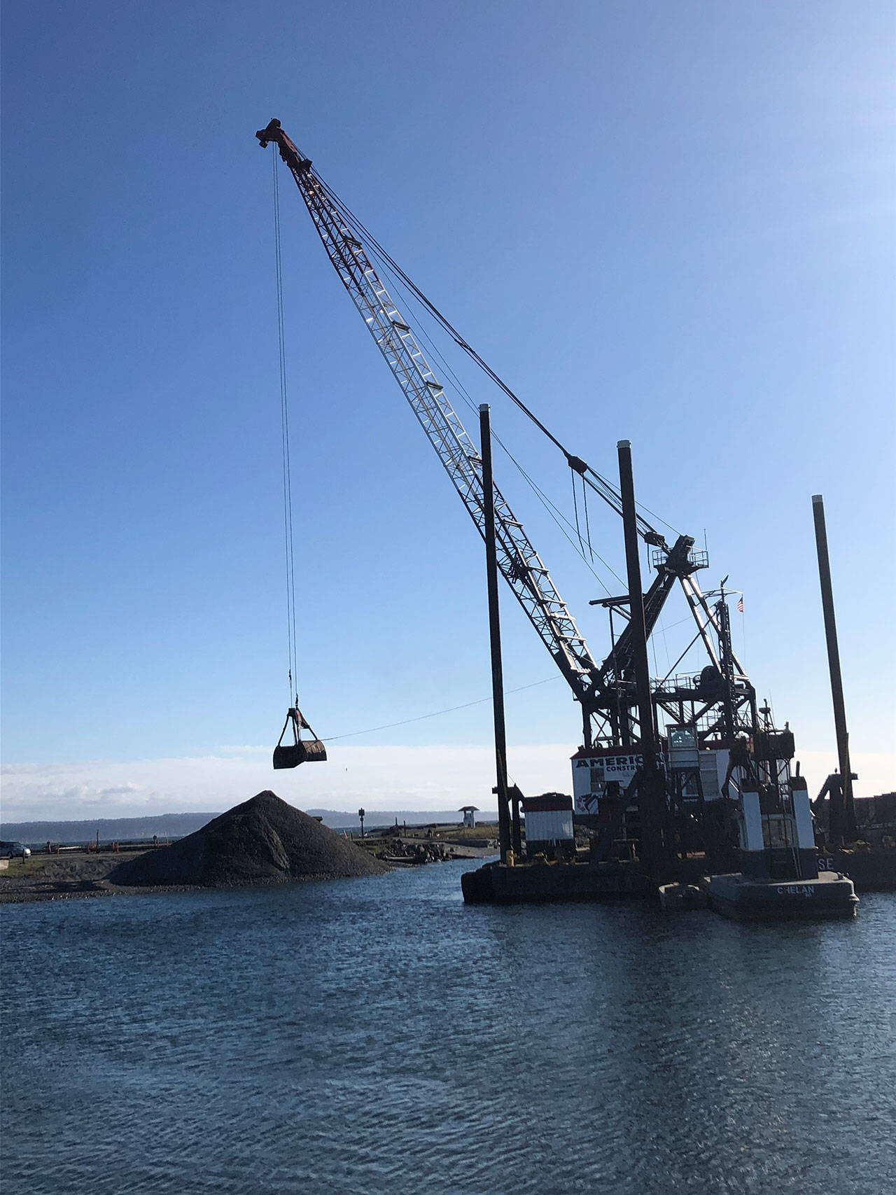 Dredging at Keystone Harbor is done every three to five years by the U.S. Army Corps of Engineers. A clam-shell dredge scoops the sediment and deposits it further up the beach. Photo by Jessie Stensland/Whidbey News-Times