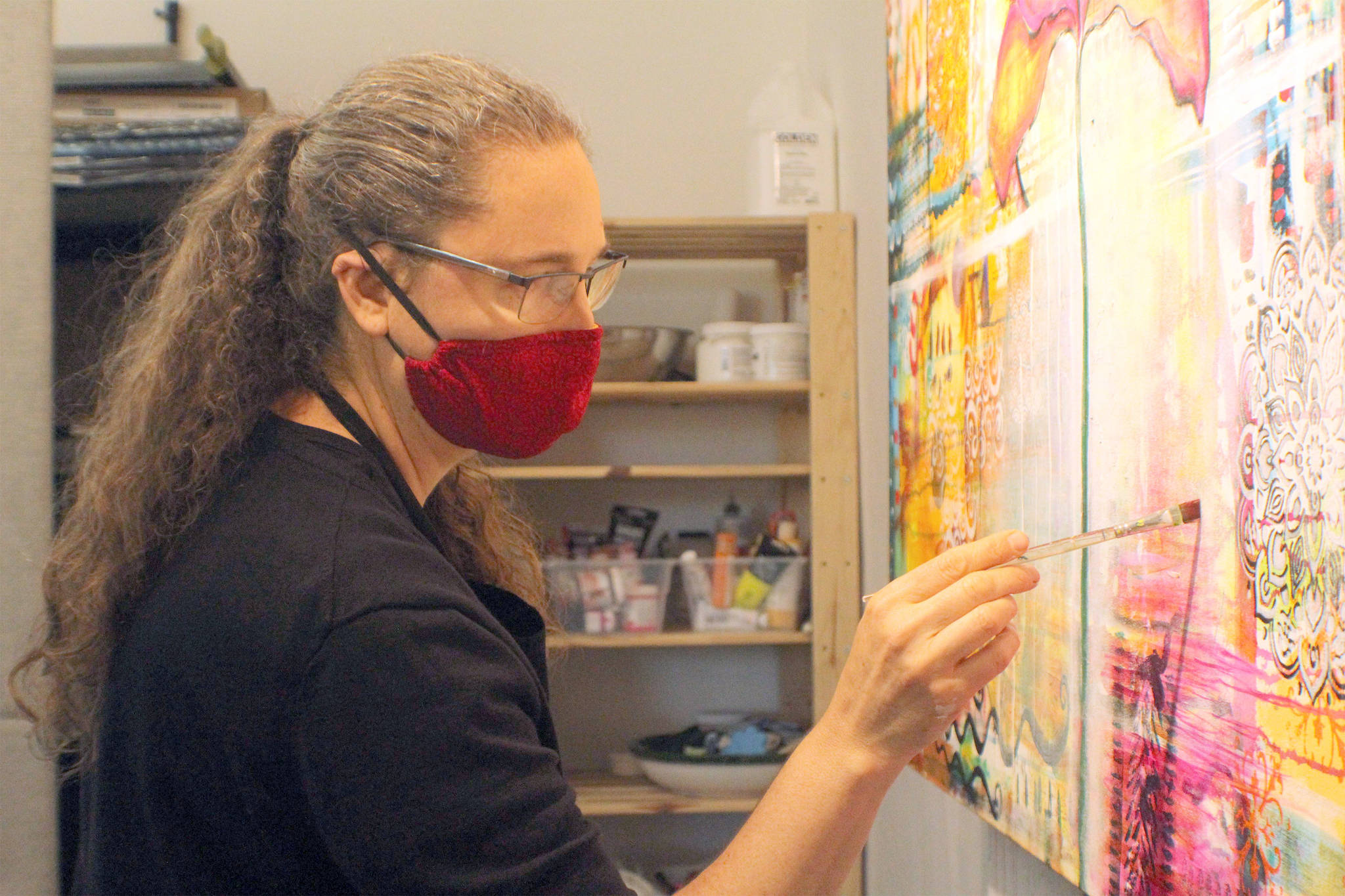 Becca Heavrin paints in her studio. (Photo by Karina Andrew/Whidbey News-Times)