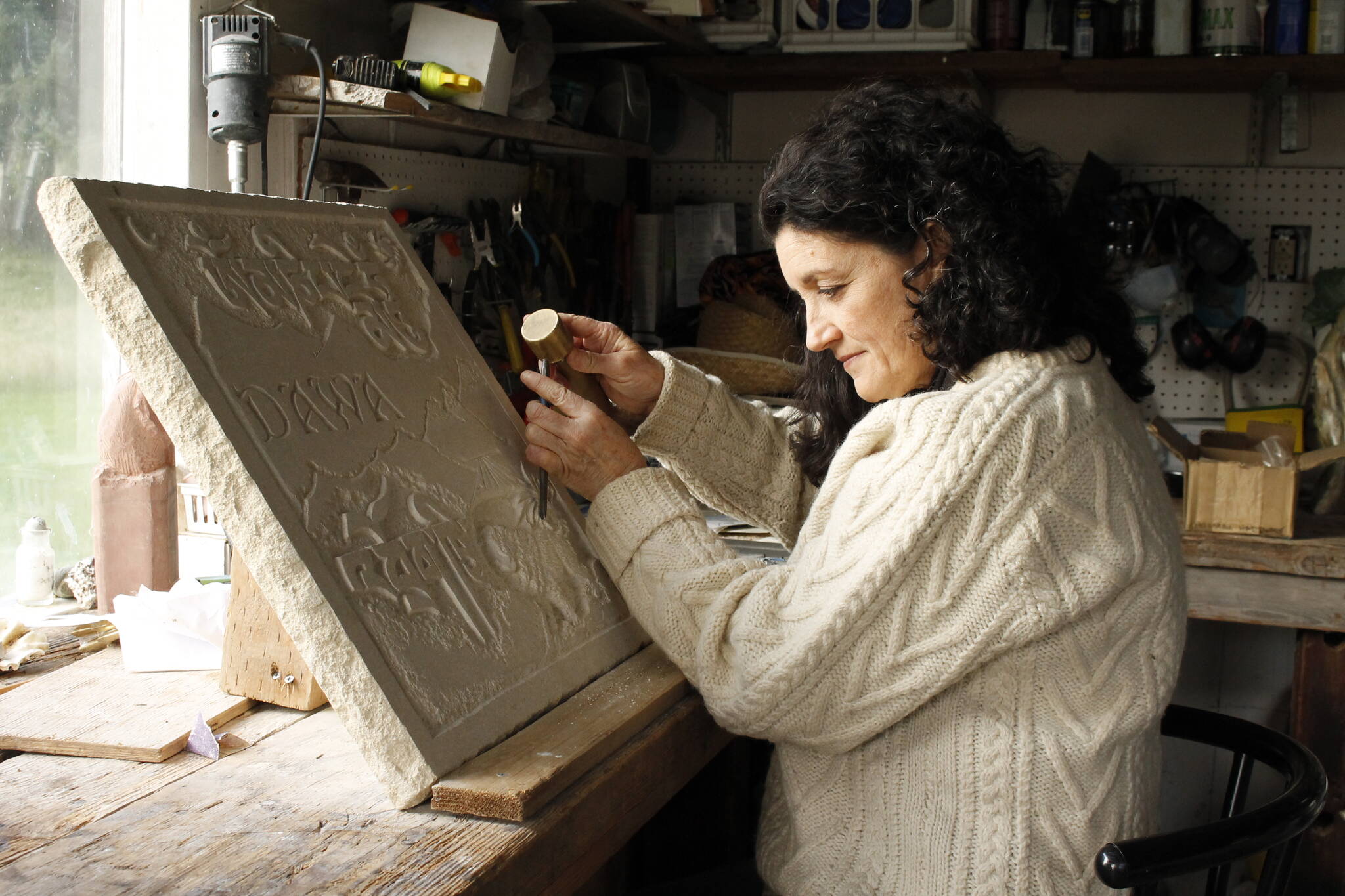 Photo by Kira Erickson/South Whidbey Record
Alexandra Morosco works on a relief carving in her studio. The art piece is a thank-you gift to the kennel where she found her faithful canine companion, a Tibetan mastiff.