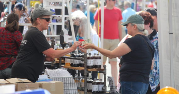 File photo by Karina Andrew/Whidbey News-Times
A Coupeville Arts and Crafts Festival patron purchases goods from a local vendor at the 2022 festival.