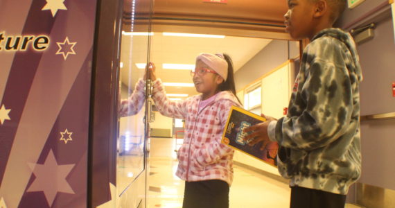 Photo by Karina Andrew/Whidbey News-Times
Cristal Hernandez Cruz, left, and Trenton Miller select books from the vending machine at Crescent Harbor Elementary School.