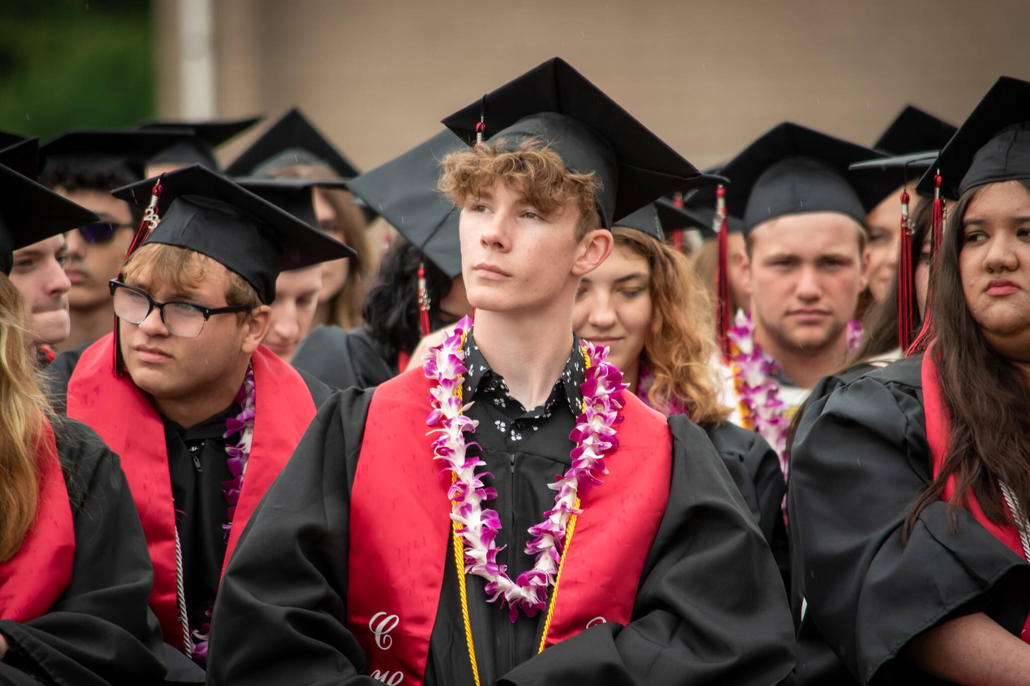 Connor Bachmann, center, and his fellow Coupeville seniors listen to presentations during Saturday’s bittersweet high school graduation. (Cynthia Woerner Photography)