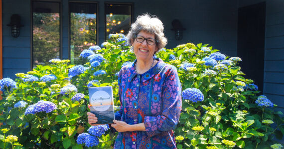 Photo by Luisa Loi
Barbara Wolf Terao holds her memoir, Reconfigured, in front of her house in Freeland.