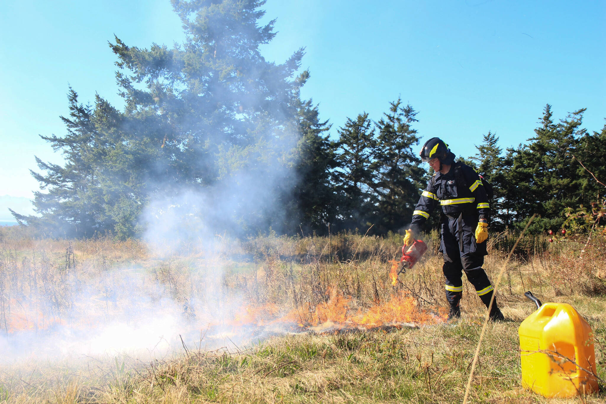 A firefighter sets the prairie on fire. (Photo by Luisa Loi/Whidbey News-Times)