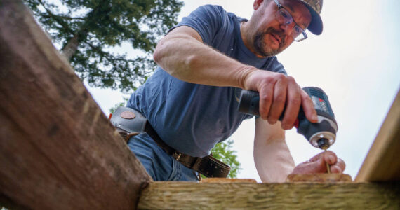 Photo by David Welton
A Hearts & Hammers volunteer repairs a deck on Saturday.