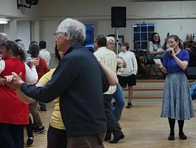 A caller, far right, directs people through the moves of a previous contra dance. (Photo provided)