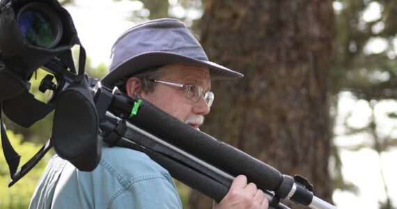 Steven Ellis carries his spotting scope through Ft. Ebey State Park. (Photo provided)