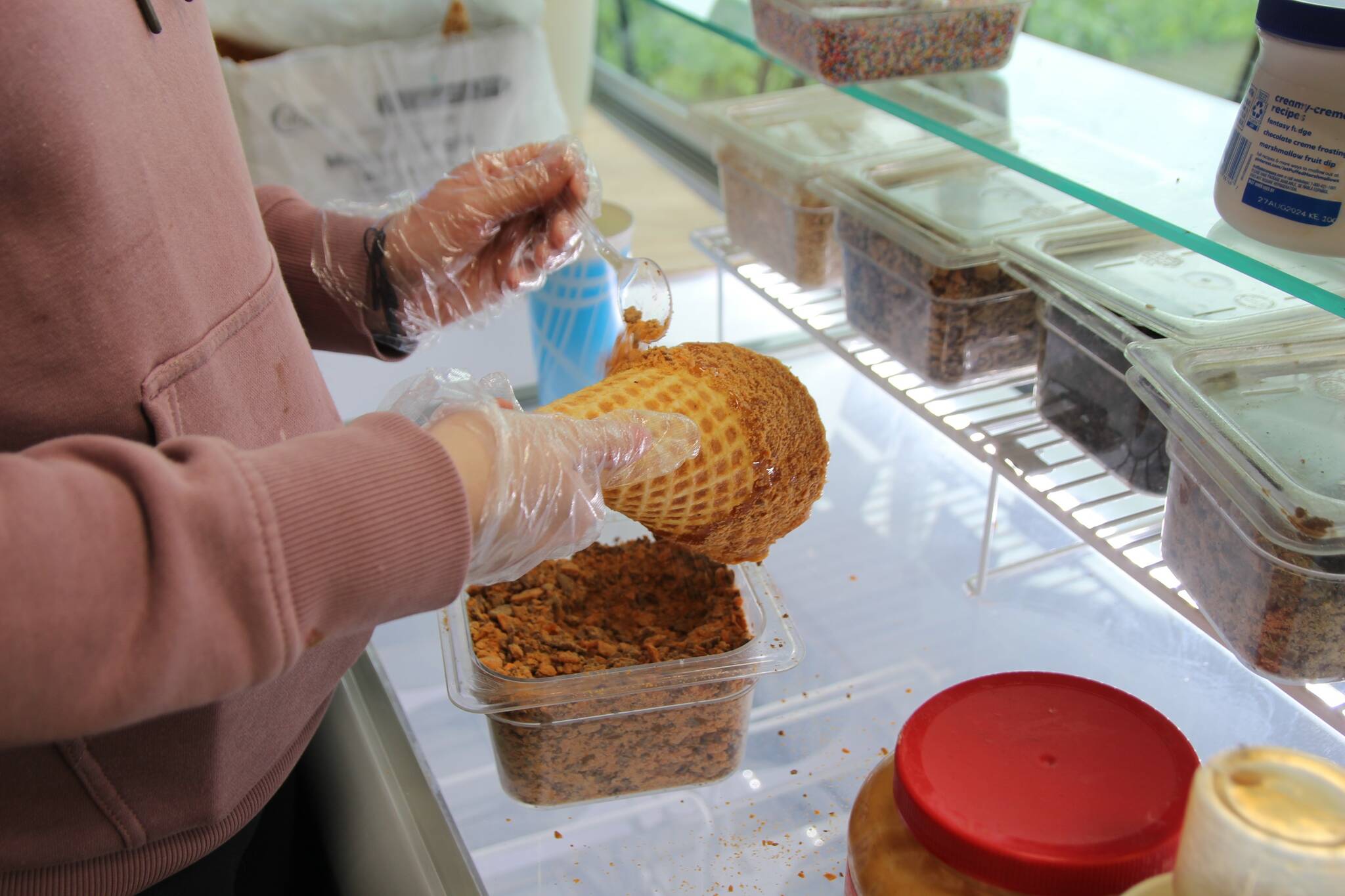 Photo by Luisa Loi
Moira Reed sprinkles Butterfinger pieces on a caramel-dipped cone.