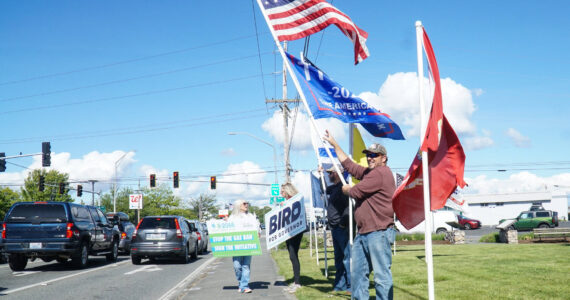 Island County Republican Party President Tim Hazelo (right) rallies with others in Oak Harbor on Thursday. (Photo by Sam Fletcher)