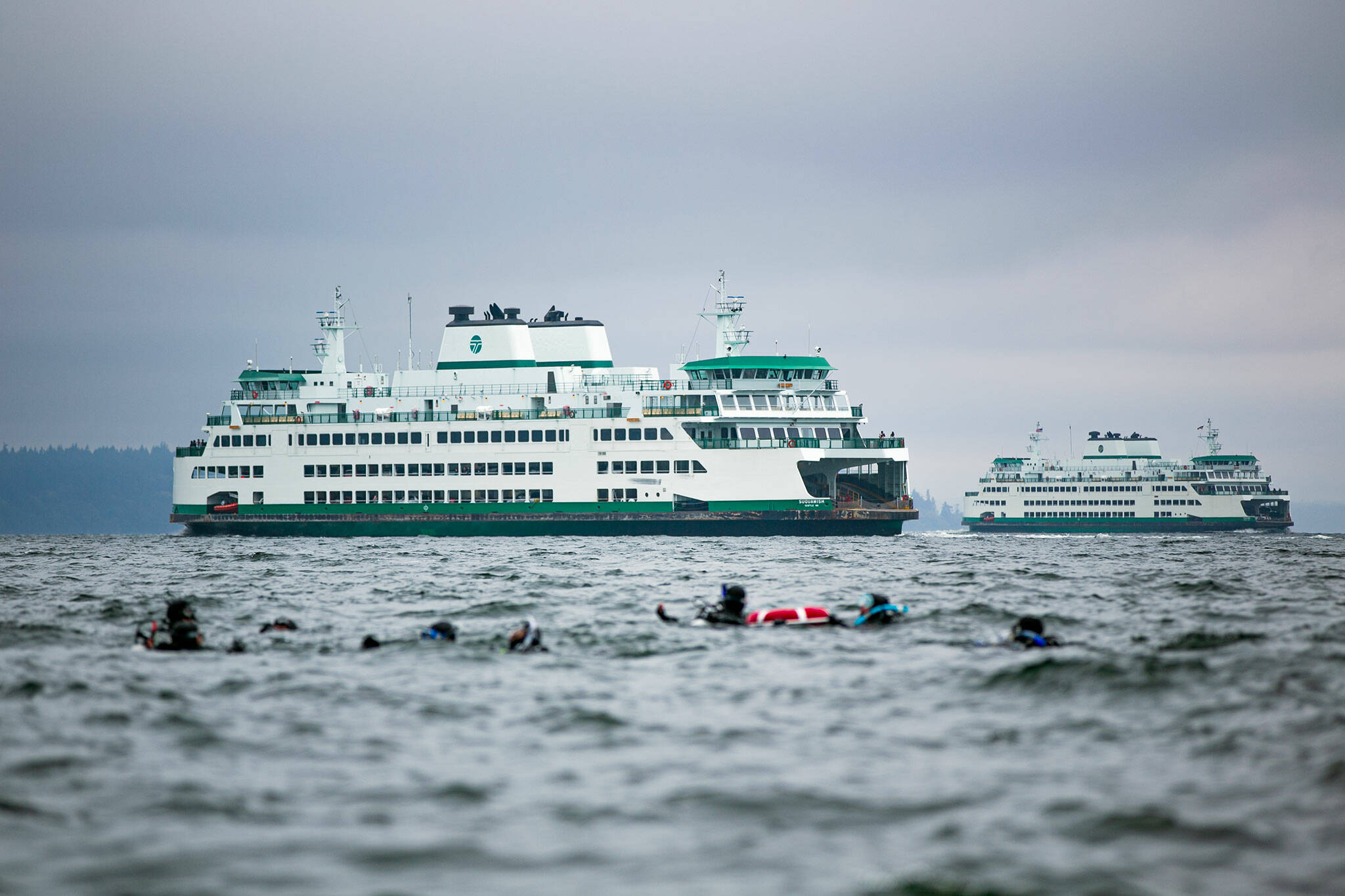Ryan Berry / The Herald
Two Washington State ferries pass along the route between Mukilteo and Clinton as scuba divers swim near the shore Sunday, Oct. 22, 2023, in Mukilteo, Washington.
