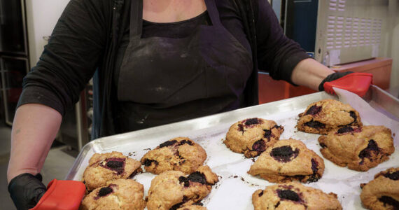 Photo by David Welton
Laura Wills holds up a tray of freshly baked marionberry scones.