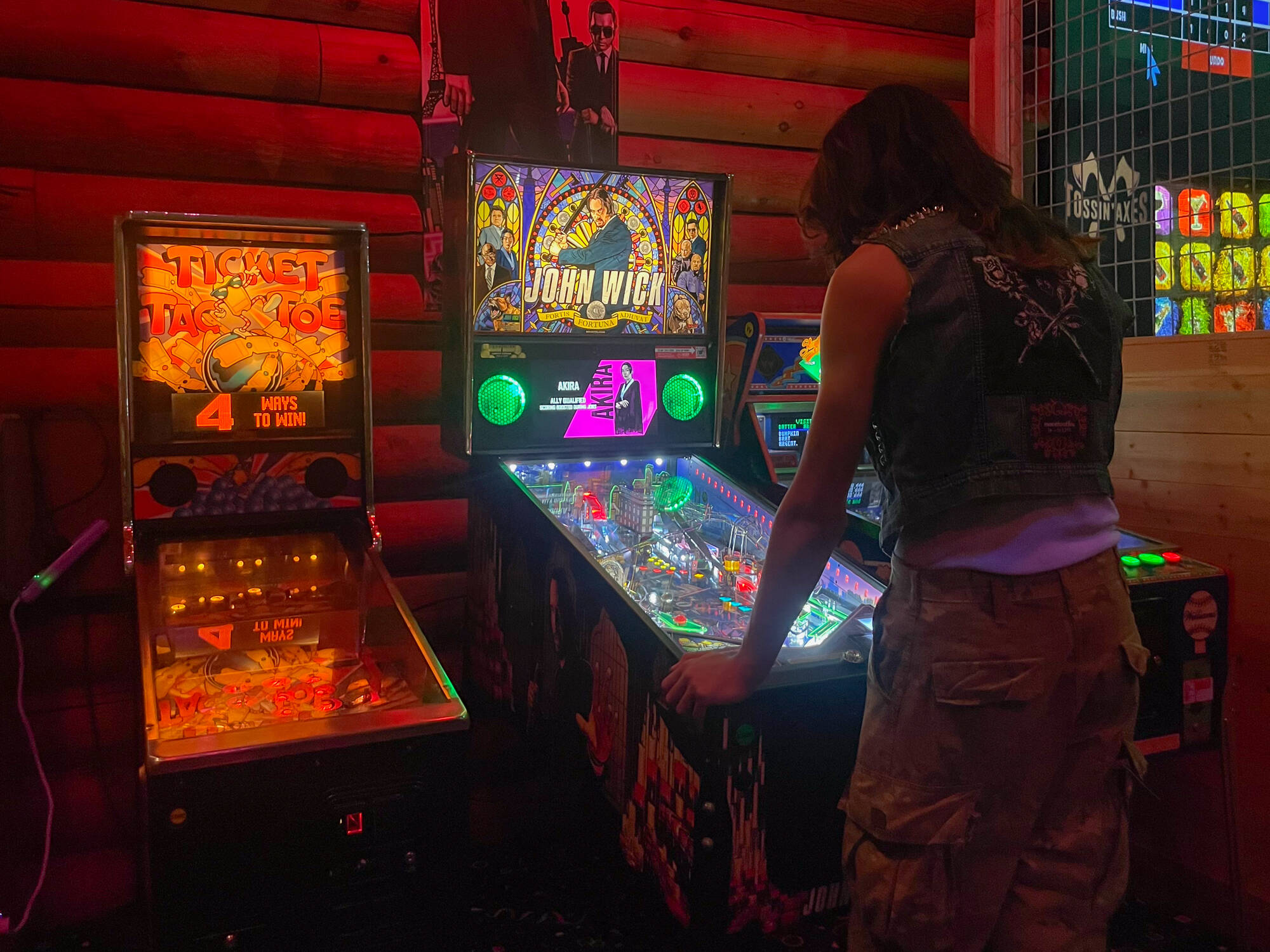 A Tossin’ Axes patron plays the new John Wick pinball machine at Friday’s launch tournament. (Photo by Caitlyn Anderson)