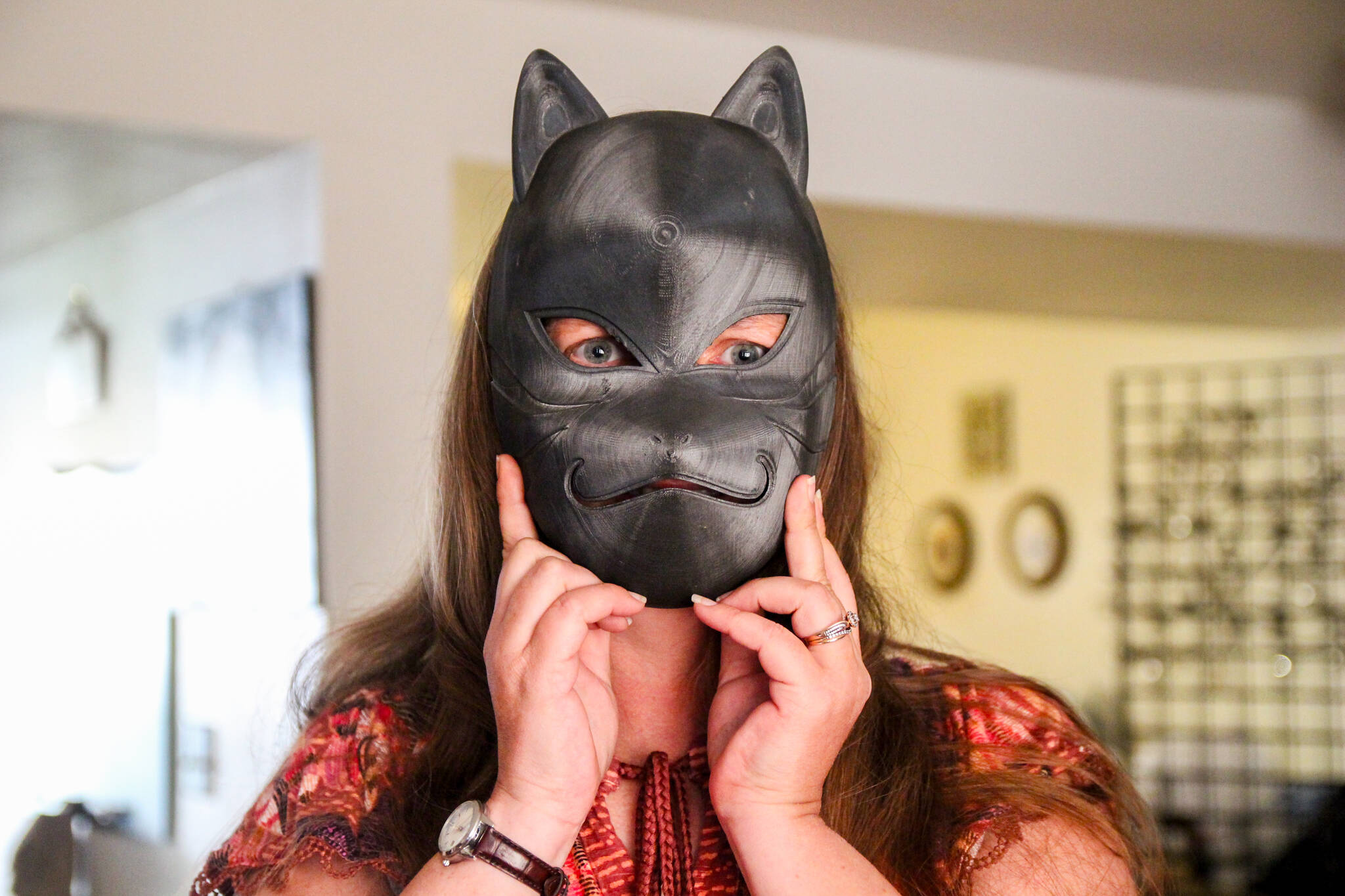 Heather Gray hides behind a cat mask she and her husband Gary printed. (Photo by Luisa Loi)