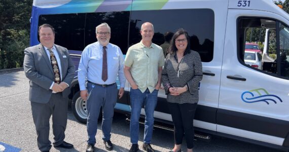 From left to right, Planning & Outreach Manager Bill Windler, Acting Director Craig Cyr, U.S. Rep. Rick Larsen and Vice Chair Jenny Bright stand before Island Transit's electric van.