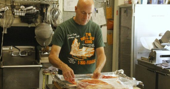 Photo by Kira Erickson/South Whidbey Record
Sean McArthur transfers some bacon onto a baking sheet in the kitchen of Whidbey Doughnuts, a beloved restaurant popular for its pastries, breakfast and lunch that is closing after Labor Day.