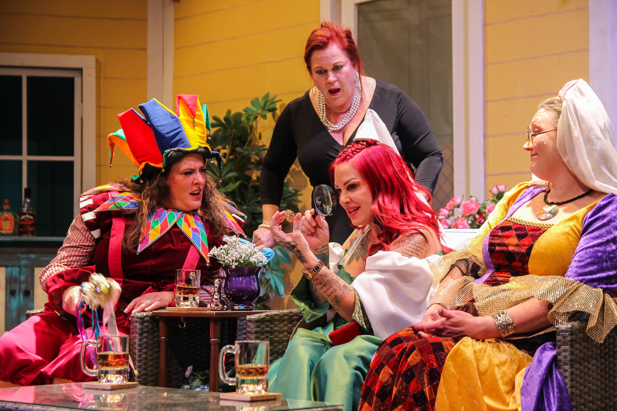 Jinx (played by Rachel Warner) examines a jewel with a magnifying lens, surrounded by Marlafaye (Katie Jones), Randa (Micki Gibson) and Dot (Amy Jones). (Photo by Luisa Loi)