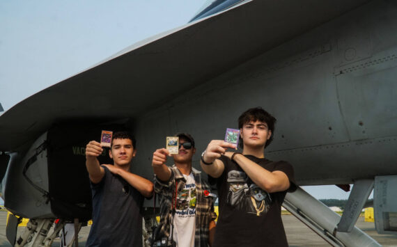 Left to right: Ty Johnon, Aiden Pieste and Cash Crites display Yu-Gi-Oh cards before a growler at Naval Air Station Whidbey Island on Saturday. (Photo by Sam Fletcher)