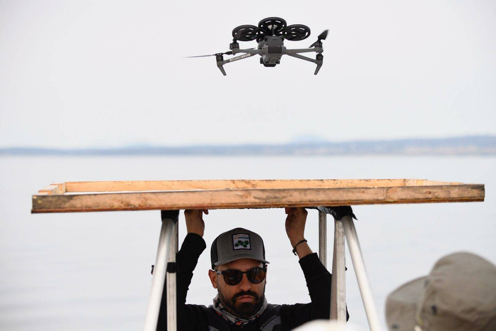 San Diego Zoo Alliance UAV pilot holds a landing pad while a drone lands after collecting breath samples. (Photo provided)