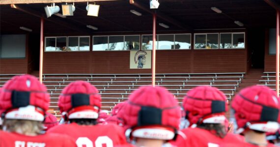 A team photo with the Stanwood High School Spartans logo in the background at Bob Larson Stadium in Stanwood, Washington on Aug. 30, 2024. (Taras McCurdie / The Herald)