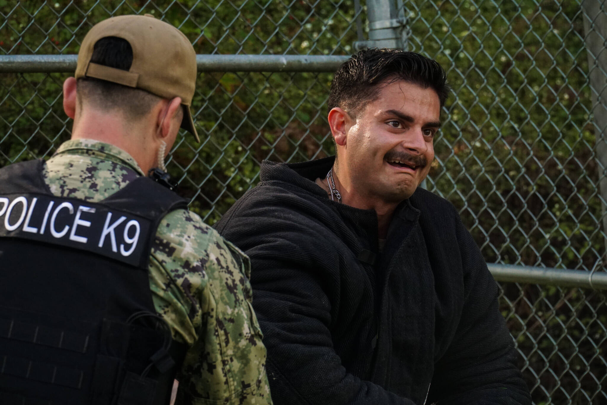 MA2 Christian Ramirez cringes with pain during a dog attack simulation. (Photo by Sam Fletcher)