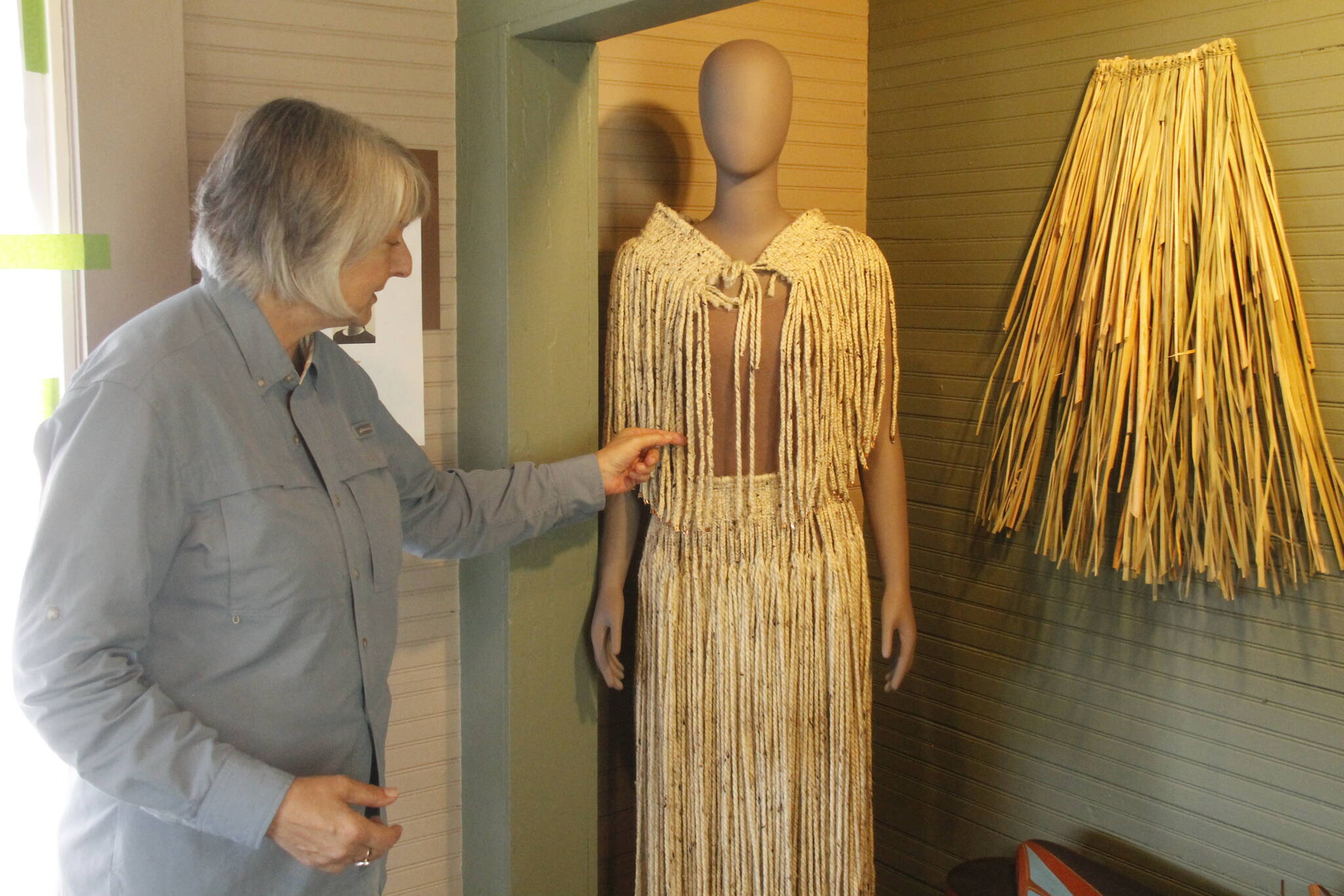 (by Kira Erickson/South Whidbey Record)
Kyle Walker arranges a display of indigenous clothing made by Pamela SeaMonster of the Snohomish Tribe.