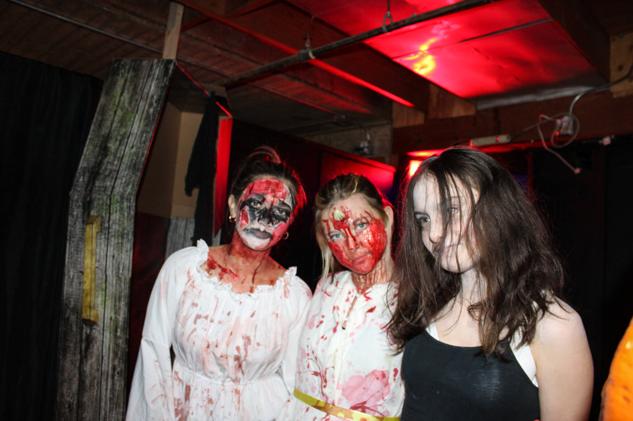 Scare actors from left: Savannah Gomez, Evelyn Vice and Miley Dutton pose at Twisted Manor at the Oak Harbor Roller Barn. (Photo by Sam Fletcher)