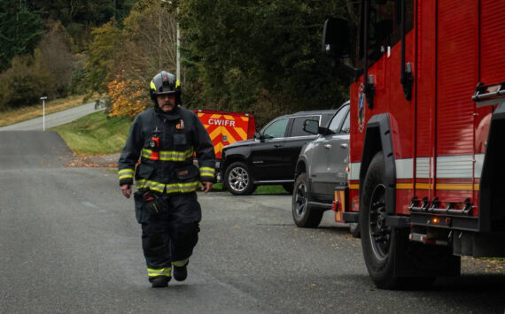 A Central Whidbey Firefighter returns to his engine. (Photo by Sam Fletcher)