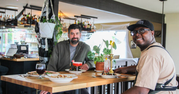 Co-Owners Sedrick Livingston, at right, and Tyler Hansen enjoy a meal at Goldie's and The Roost, a restaurant they opened with Sophia Jones.