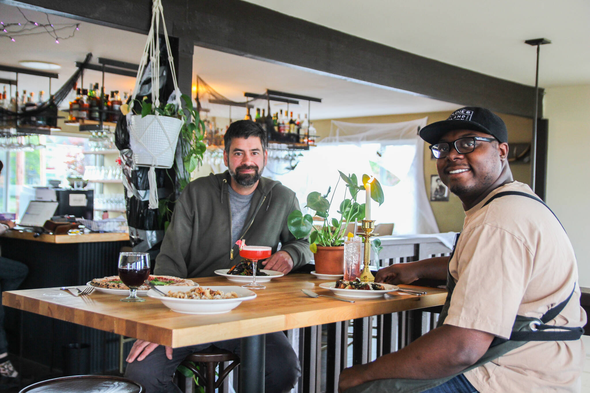 Co-owners Tyler Hansen, at left, and Sedrick Livingston enjoy a meal at Goldie’s and The Roost, a restaurant they opened with Sophia Jones. (Photo by Luisa Loi)