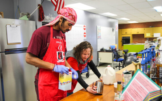 (Photo by Luisa Loi)Transition Specialist Erin Straub assists Nehemiah Myles in making an egg nog latte for a reporter.