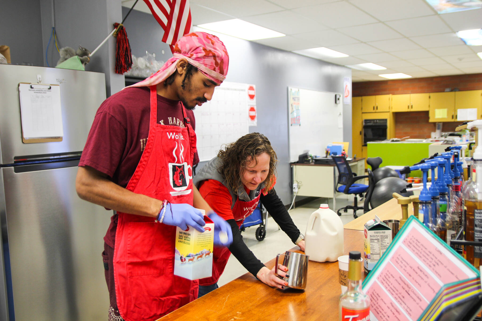 Transition Specialist Erin Straub assists Nehemiah Myles in making an eggnog latte for a reporter. (Photo by Luisa Loi)