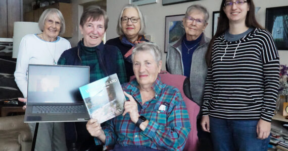 Photo by Sam Fletcher
Whidbey Writers Group poses with its newest release, “Whidbey Island: An Insider’s Guide” on Tuesday.