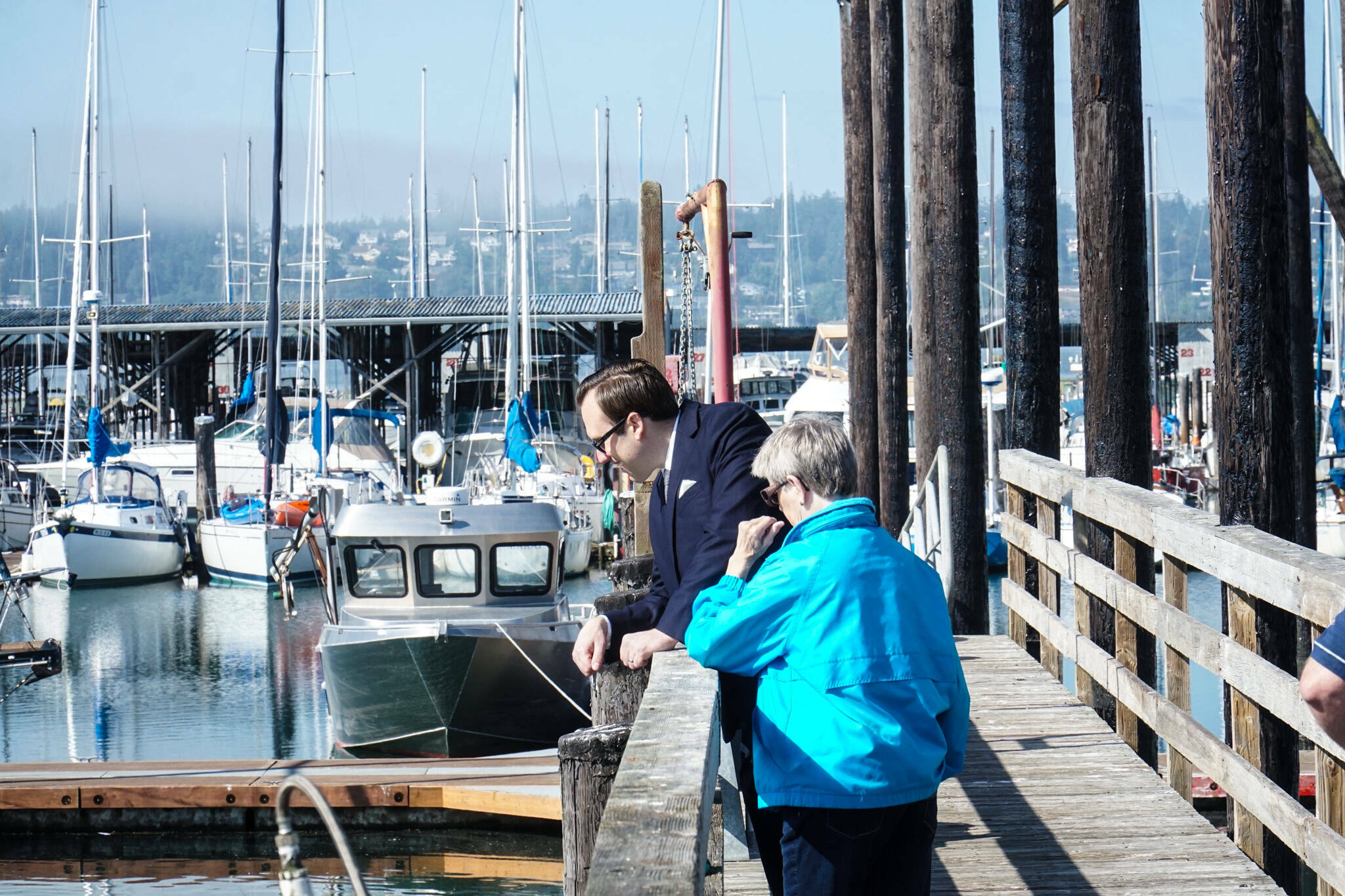 Councilmembers Bryan Stucky and Barbara Armes watch a seal at the Oak Harbor marina. (Photo by Sam Fletcher)